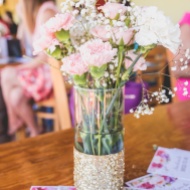 Pink and white carnations with babys breath in clear vases with gold glitter bottoms. Gorgeous centerpieces for a bridal shower.
